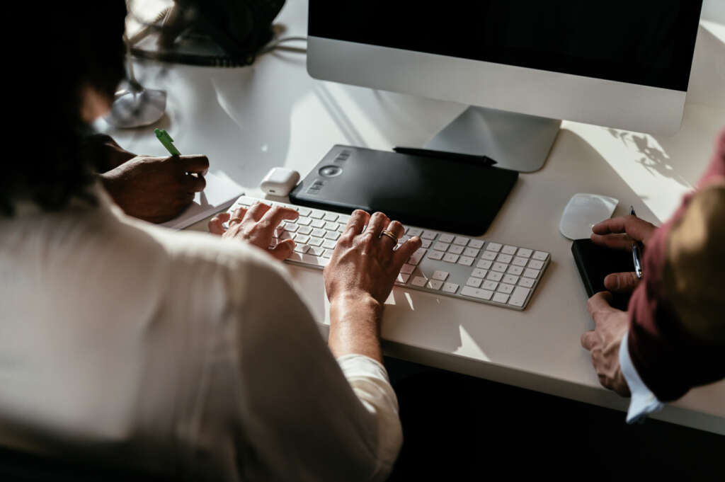 Colleagues solving a problem together at a computer